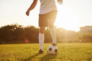 Beautiful sunshine. Young soccer player have training on the sportive field photo