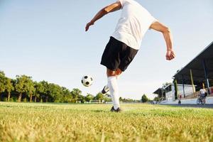 Kicks the ball. Young soccer player have training on the sportive field photo