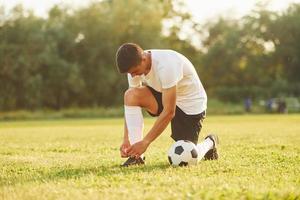 Preparing for the game. Young soccer player have training on the sportive field photo