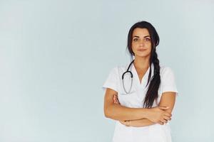 Young female doctor in white uniform is indoors photo