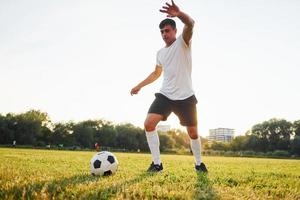 Active weekend activies. Forest on background. Young soccer player have training on the sportive field photo