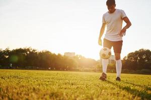 Doing different tricks. Young soccer player have training on the sportive field photo