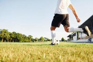 Kicks the ball. Young soccer player have training on the sportive field photo