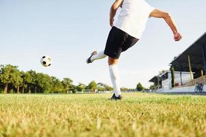 Kicks the ball. Young soccer player have training on the sportive field photo