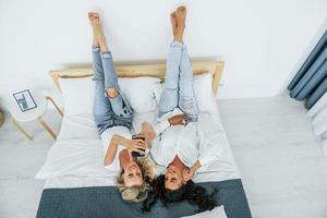 Upside down view. Laying down on bed. Two women is together at home photo