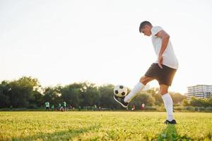 Doing different tricks. Young soccer player have training on the sportive field photo