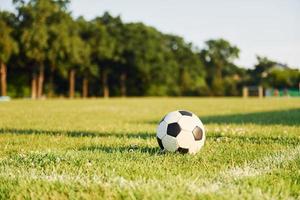 Close up view of soccer ball that lying down on the green grass photo