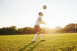 Forest on background. Young soccer player have training on the sportive field photo