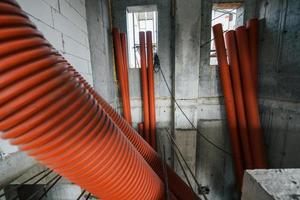 dentro del edificio sin terminar. tubos de color naranja foto