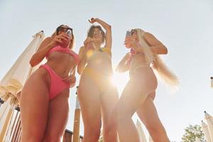 las mujeres en traje de baño se divierten juntas al aire libre en verano foto