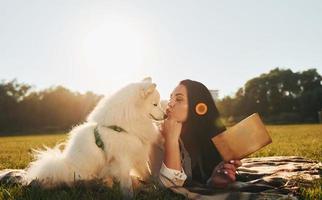 Woman with her dog is having fun on the field at sunny daytime photo