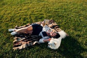 Top view. Woman with her dog is having fun on the field at sunny daytime photo