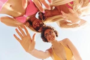 View from below. Women in swimsuits have fun outdoors together at summertime photo