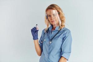 usando máscara protectora. joven doctora en uniforme está adentro foto