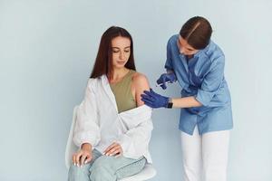 SImple but effective procedure. Doctor in uniform making vaccination to the patient photo