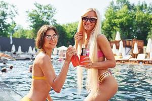 Women in swimsuits have fun outdoors together at summertime photo