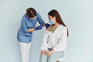 SImple but effective procedure. Doctor in uniform making vaccination to the patient photo