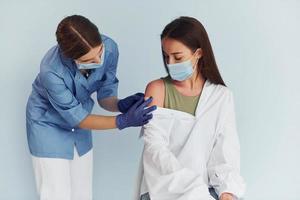 SImple but effective procedure. Doctor in uniform making vaccination to the patient photo