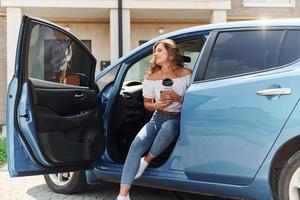 mujer joven en ropa casual con su electromóvil al aire libre durante el día foto