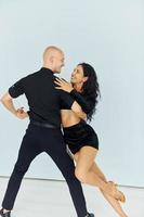 bailando en el estudio con fondo blanco. una pareja alegre está junta en el interior foto