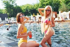 Two friends. Women in swimsuits have fun outdoors together at summertime photo