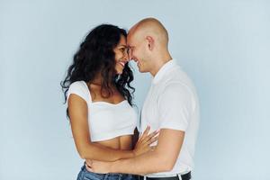 Man in white clothes and woman in jeans. Cheerful couple is together indoors photo