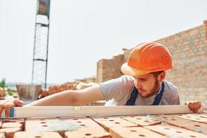 Busy day. Young construction worker in uniform is busy at the unfinished building photo