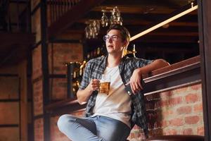 Descansando. hombre con ropa informal sentado en el pub foto