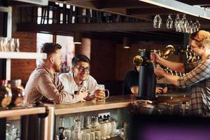 grupo de personas con ropa informal sentadas en el pub foto