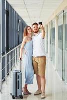 pareja feliz. el joven viajero está en el vestíbulo de entrada del aeropuerto foto