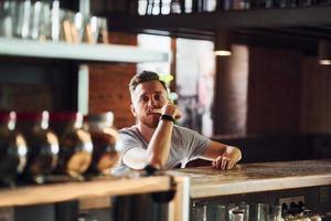 Young man in casual clothes sitting in the pub photo