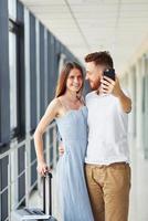 Two people. Young traveler is on the entrance hall in the airport photo