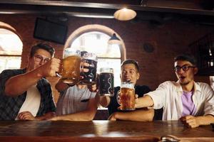 beber cerveza. gente con ropa informal sentada en el pub foto