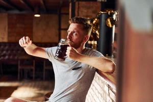 Man in casual clothes sitting in the pub at daytime photo