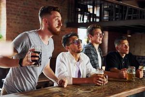 Alcoholic drinks. People in casual clothes sitting in the pub photo