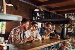 durante el día. gente con ropa informal sentada en el pub foto