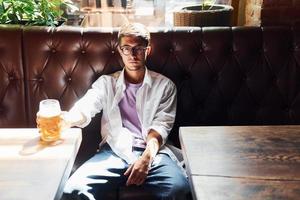 Beautiful interior. Man in casual clothes sitting in the pub photo