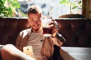 On the chair. Man in casual clothes sitting in the pub photo