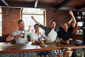 By the table. People in casual clothes sitting in the pub photo