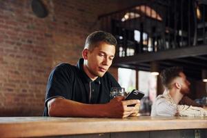 Beautiful interior. Man in casual clothes sitting in the pub photo