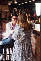 Cheerful young people in casual clothes sitting in the pub photo