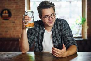 Beautiful interior. Man in casual clothes sitting in the pub photo