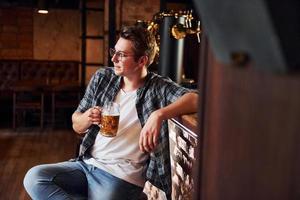 una persona. hombre con ropa informal sentado en el pub foto