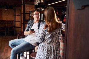 hombre y mujer. gente con ropa informal sentada en el pub foto