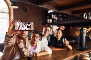 Making selfie. People in casual clothes sitting in the pub photo