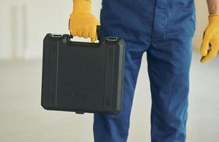 Close up view. Young man working in uniform at construction at daytime photo