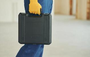 Close up view. Young man working in uniform at construction at daytime photo