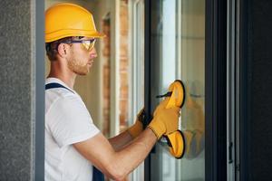 In protective wear. Young man working in uniform at construction at daytime photo