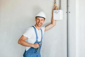 Modern technologies. Young man working in uniform at construction at daytime photo