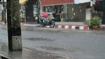 Vue vidéo 4k sur la route locale dans la ville de phuket sous de fortes pluies video
